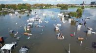 Maas buiten oevers getreden, camping en beachclub overvallen door hoogwater