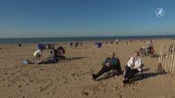 Eerste zachte dag van het jaar: mensen genieten in de zon op het strand